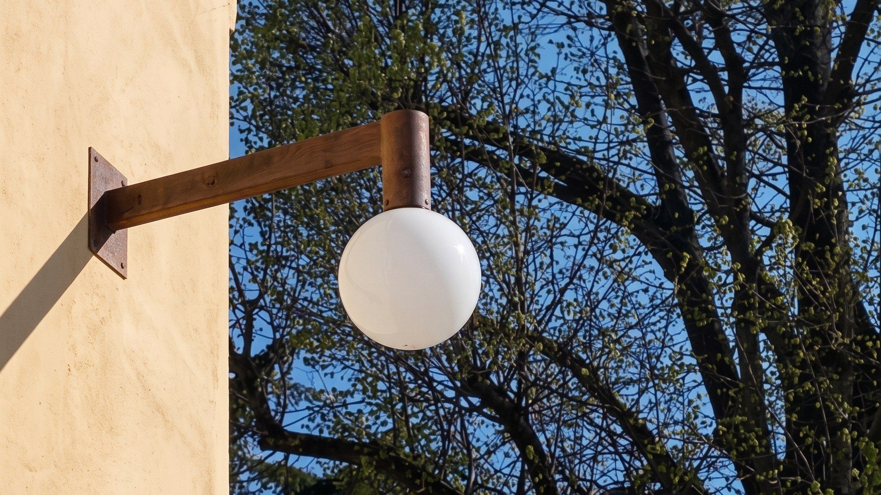 Applique a sfera in vetro di Murano satinato sulla facciata dell'Istituto Costante Gris a Mogliano Veneto