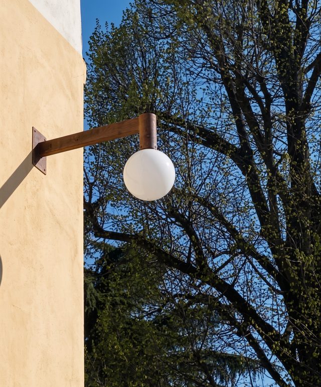 Applique a sfera in vetro di Murano satinato sulla facciata dell'Istituto Costante Gris a Mogliano Veneto